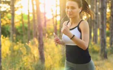 woman running outdoors in daylight with headphones