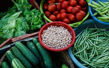 Picture of fruits and vegetables around uncooked black eyed peas. These foods are great for mental health.