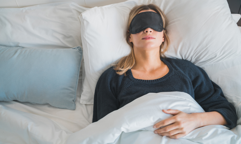 Photo of woman asleep in bed wearing a sleep mask
