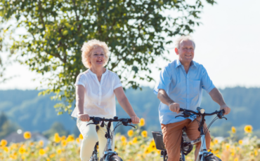 Elder couple riding their biked outside during summer