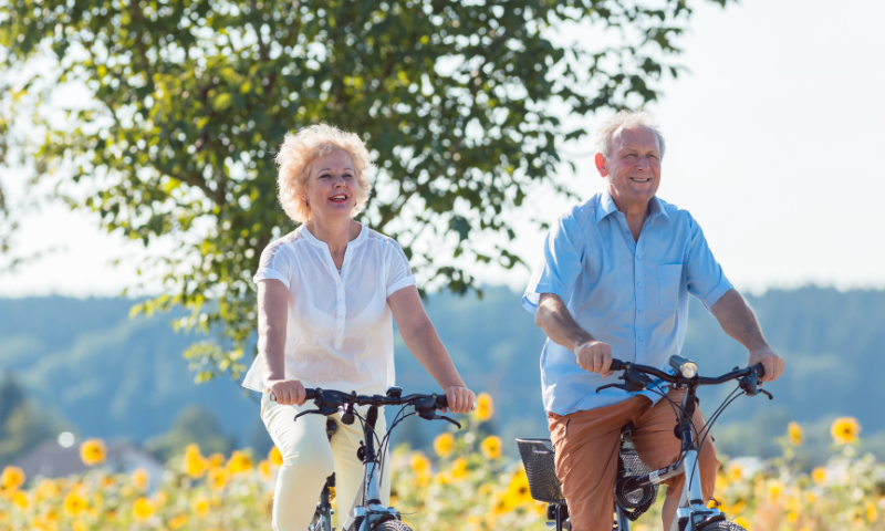 Elder couple riding their biked outside during summer