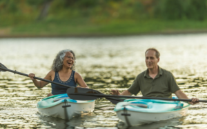 Middle aged man and and woman kayaking on the water