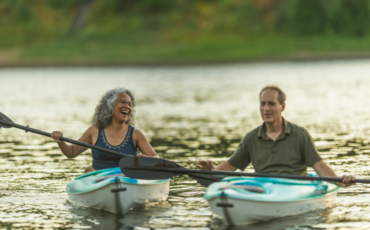 Middle aged man and and woman kayaking on the water