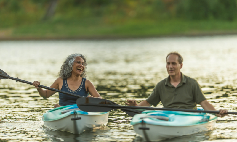 Middle aged man and and woman kayaking on the water