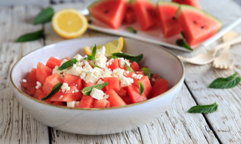 Bowl of watermelon, mint, feta salad with some fresh squeezed lemon