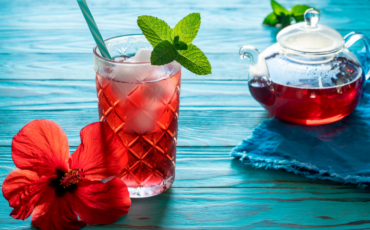 Glass and pitcher of hibiscus iced tea