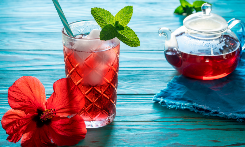 Glass and pitcher of hibiscus iced tea