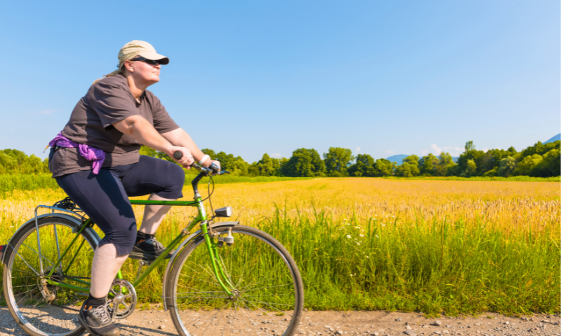 Middle age woman riding bike in summer