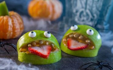 Halloween apple monsters with peanut butter, strawberries and dark chocolate