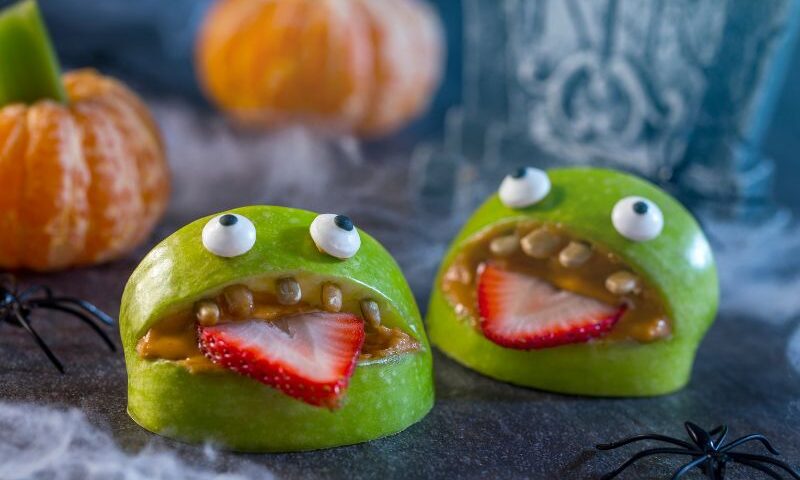 Halloween apple monsters with peanut butter, strawberries and dark chocolate