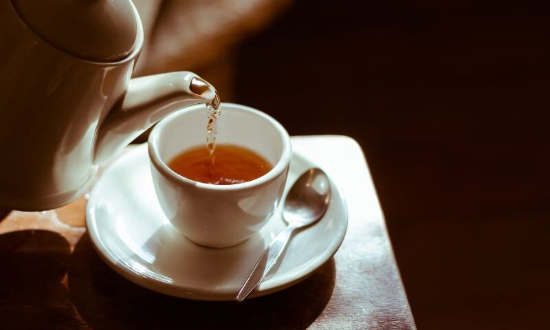 Image of a teapot filling a teacup with herbal tea