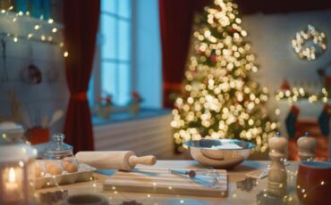 Photo of baking tools and ingredients for baking cookies, in front of a holiday tree