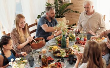 family gathers around a table for a holiday dinner