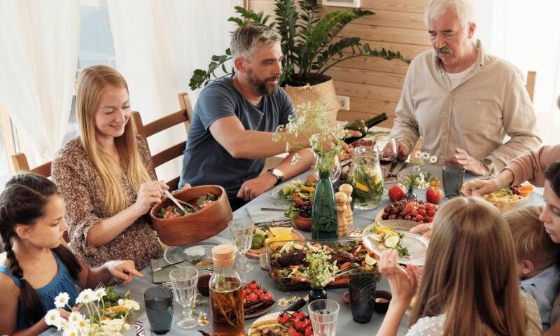 family gathers around a table for a holiday dinner