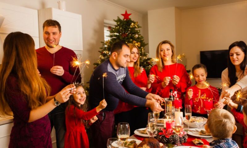 Holiday gathering around the table and in front of the Christmas tree