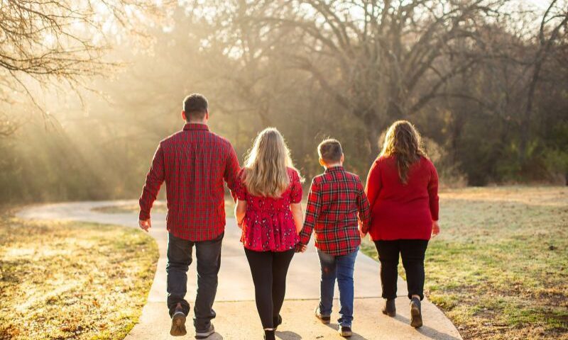 Four people dressed in holiday red go on a walk outside